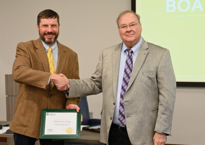 Board member James Young, left, is presented his Board Leadership Certificate by Board President Jeff Joines. 